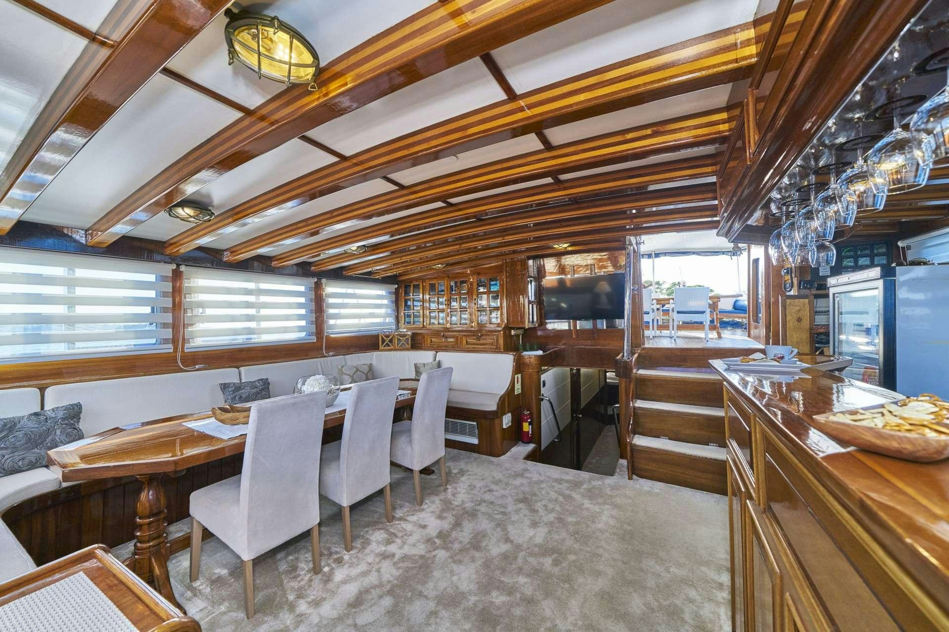 a room with a table chairs and a large window aboard PERLA Yacht for Charter
