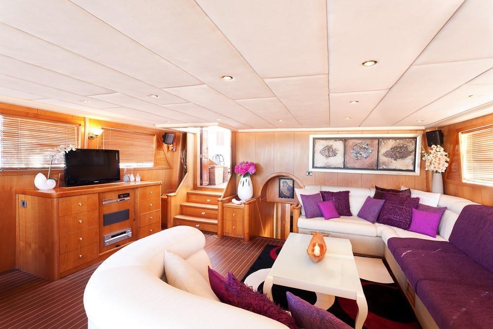 a living room with a couch and a television aboard AEGEAN SCHATZ Yacht for Charter
