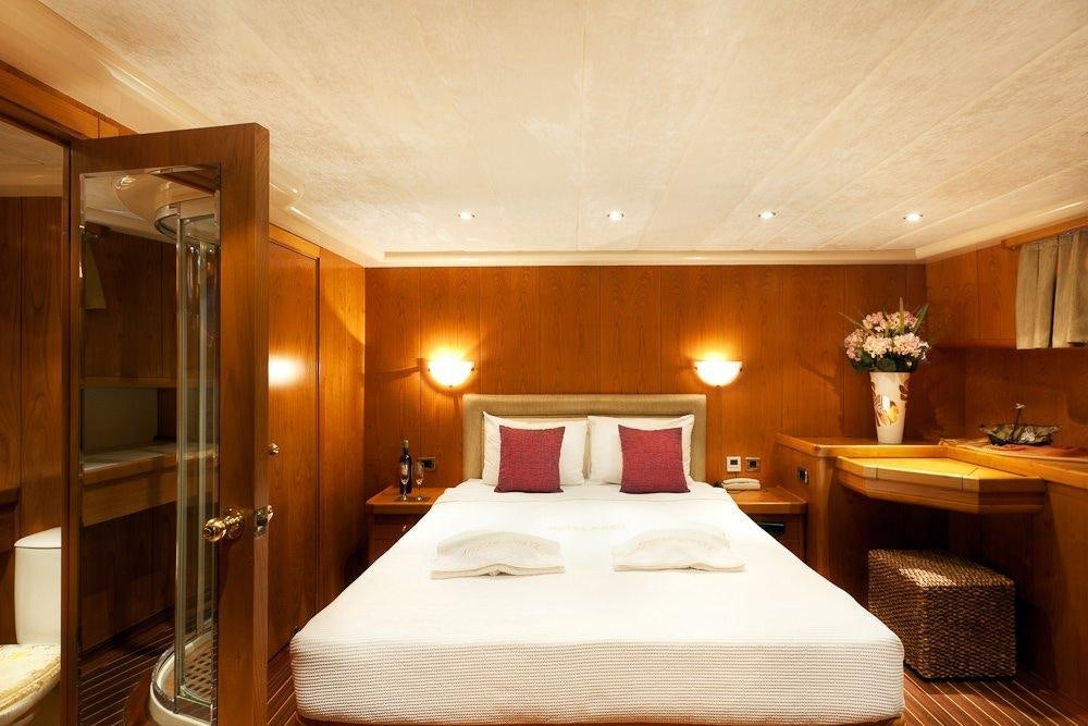 a bed with pink pillows aboard AEGEAN SCHATZ Yacht for Charter