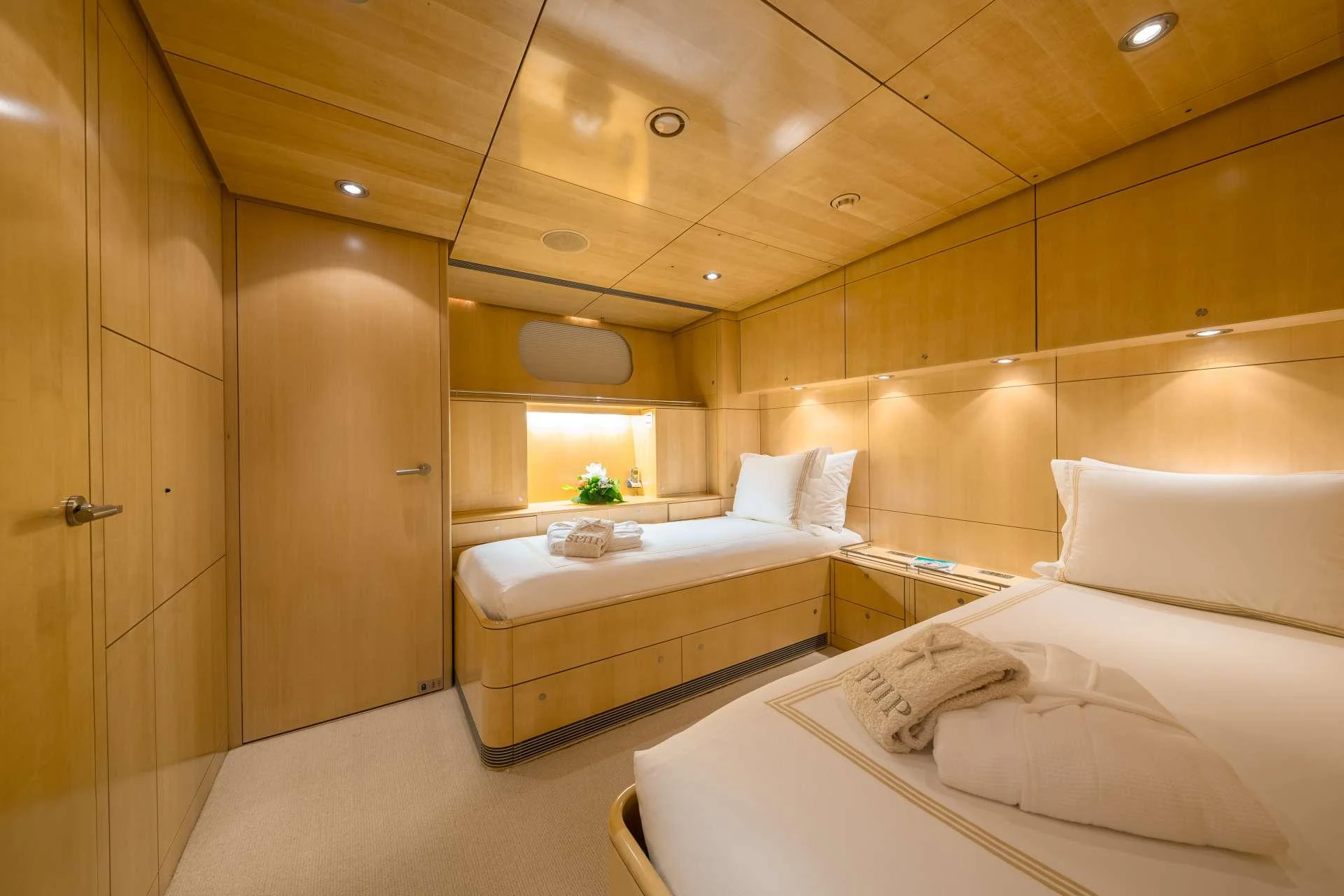 The guest stateroom features warm wood paneling and cozy bedding for a comfortable stay. aboard SPIIP Yacht for Charter