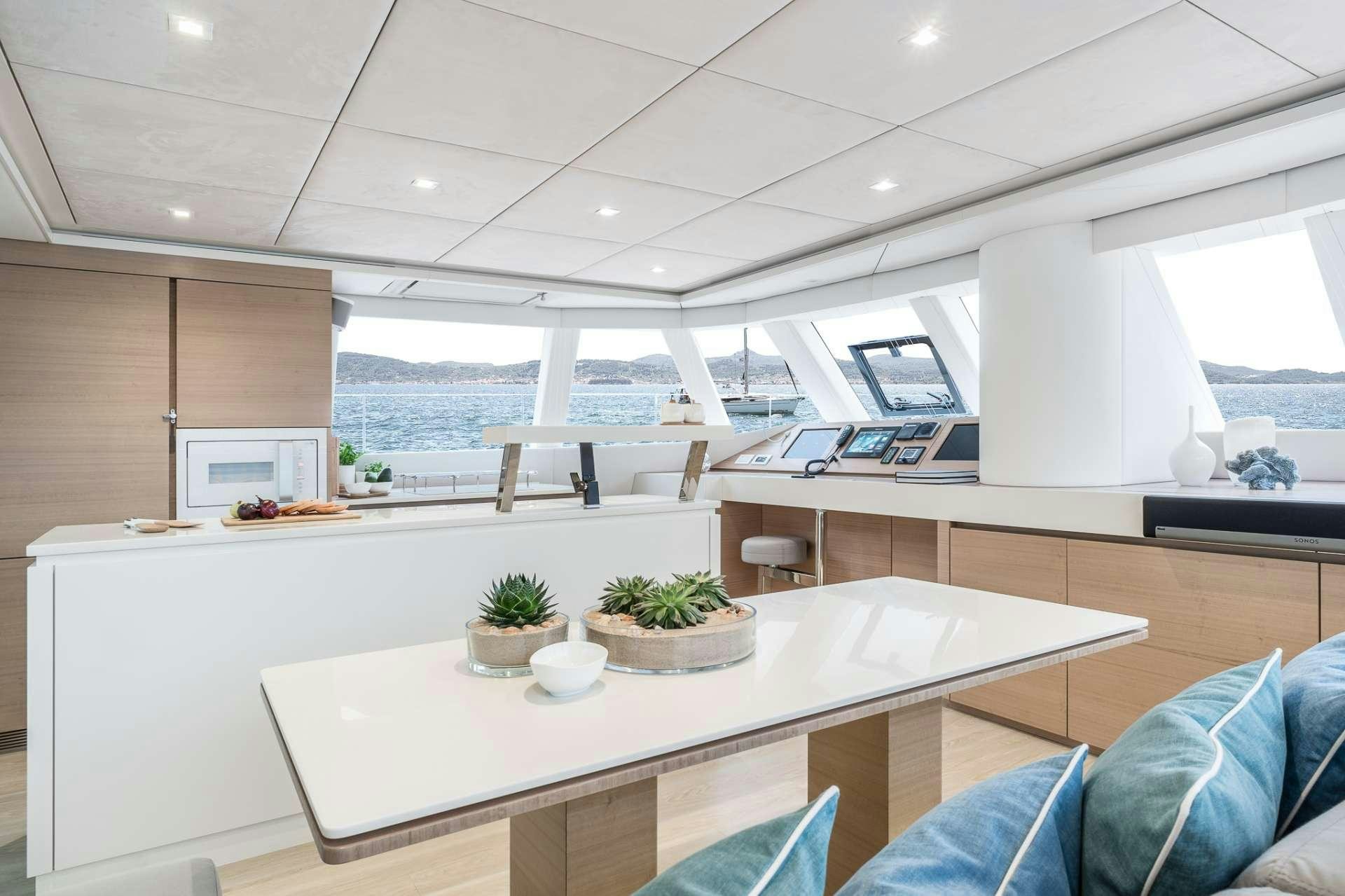 a modern looking room with a large white table and a large window aboard ANNETTE2 Yacht for Charter