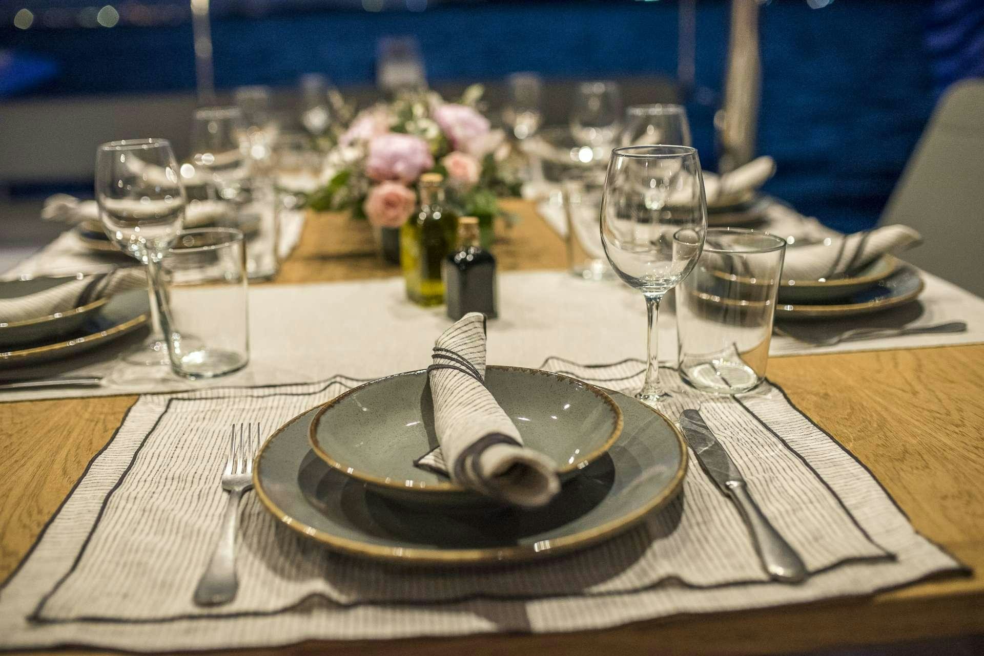 a table with a plate of food and glasses on it aboard Sea Energy V Yacht for Charter