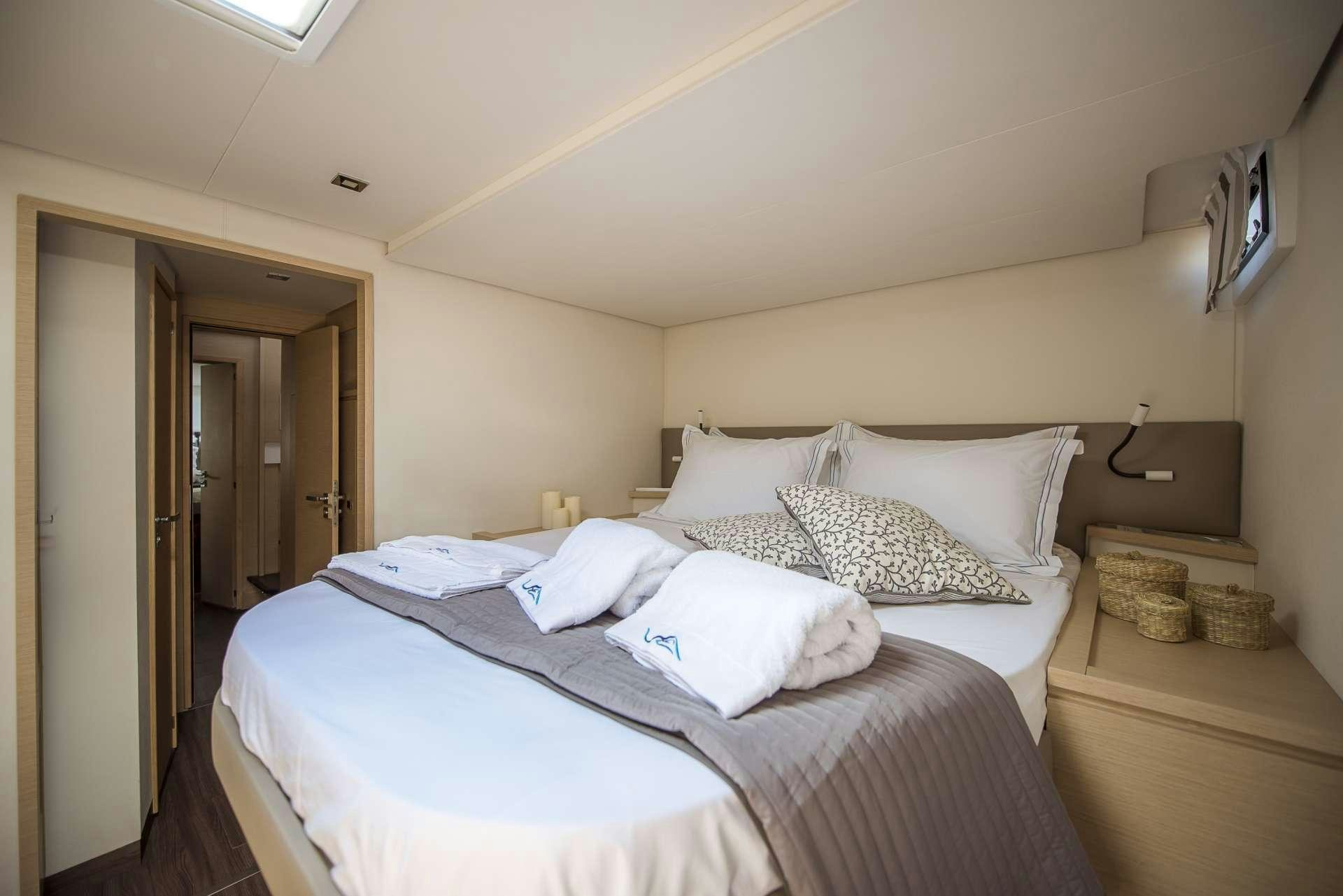 a bedroom with a bed and a television on the wall aboard Sea Energy V Yacht for Charter