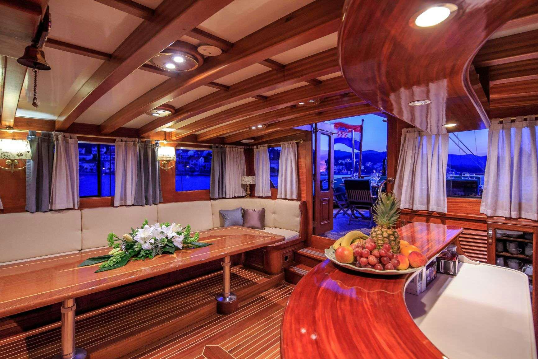 a large room with a table and a couch aboard Carpe Diem 7 Yacht for Charter