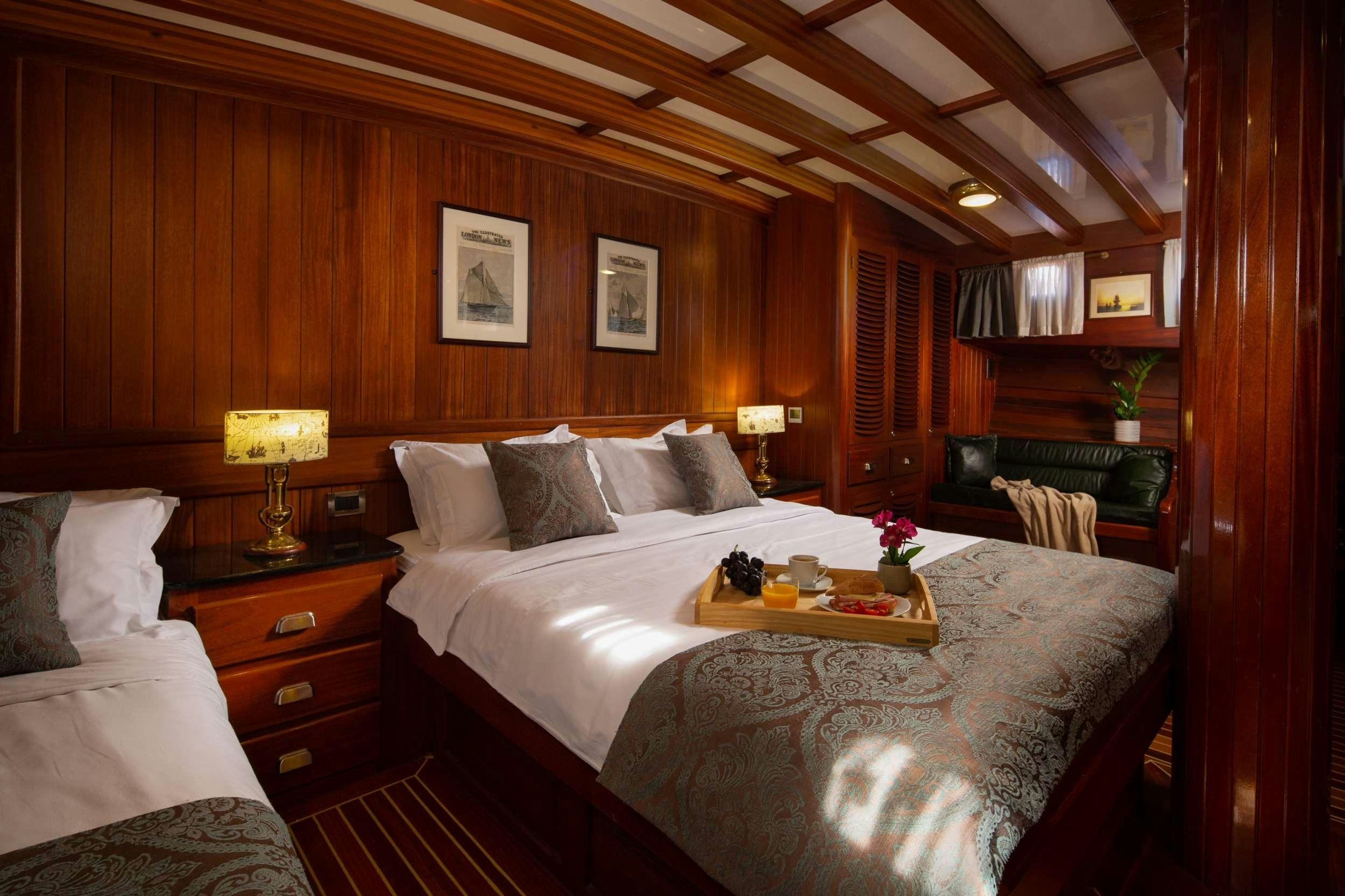 a bed with a white bed spread aboard Carpe Diem 7 Yacht for Charter