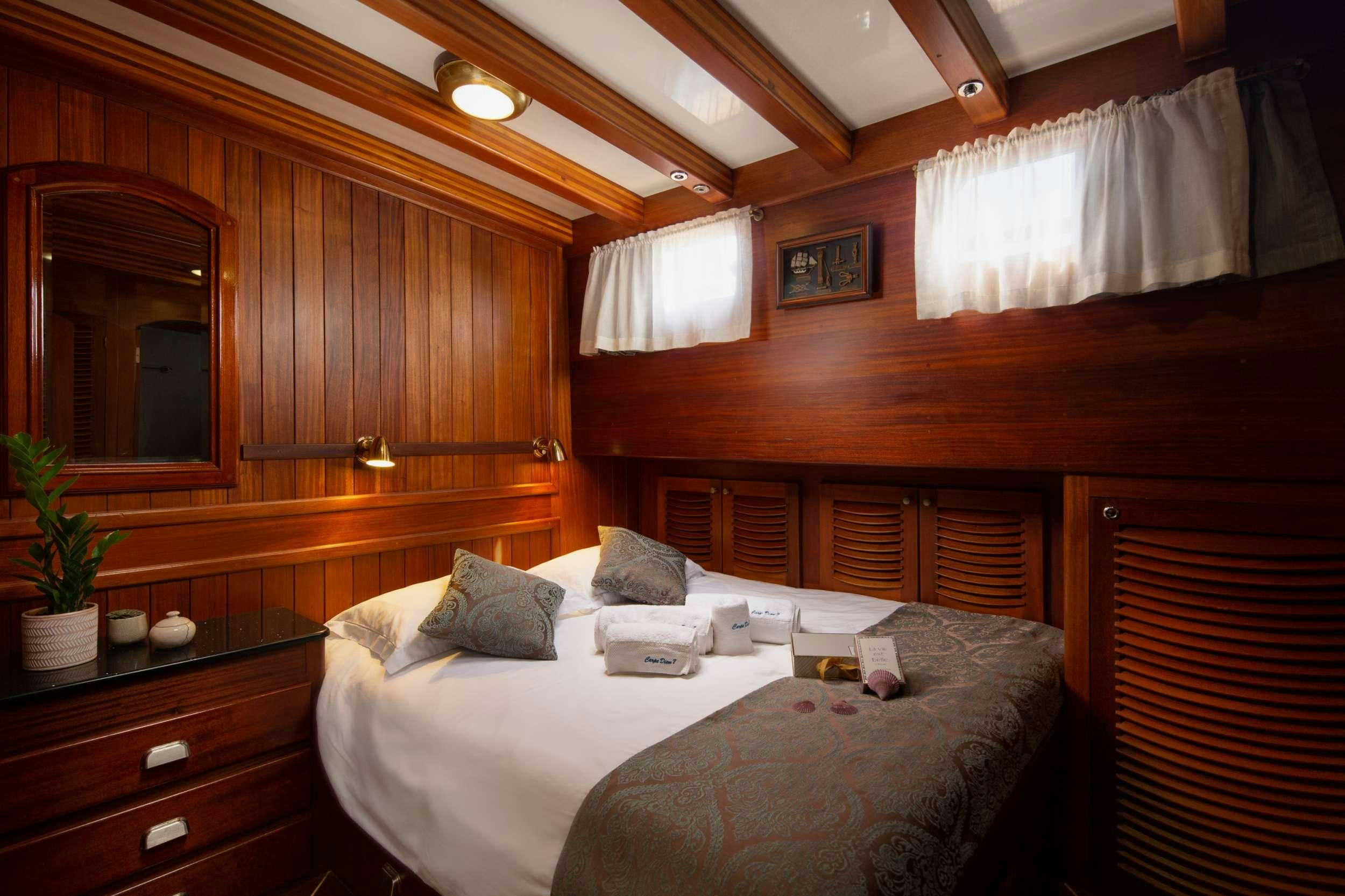 a room with a bed and a mirror aboard Carpe Diem 7 Yacht for Charter