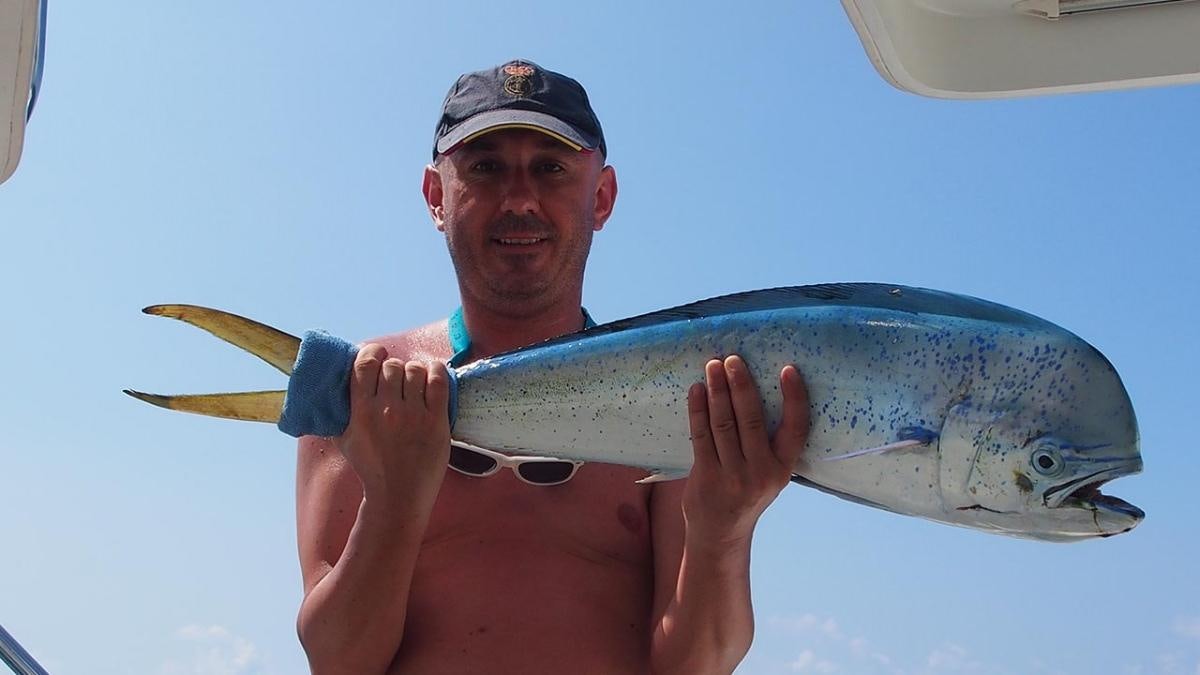 a person holding a fish aboard FRENK Yacht for Charter