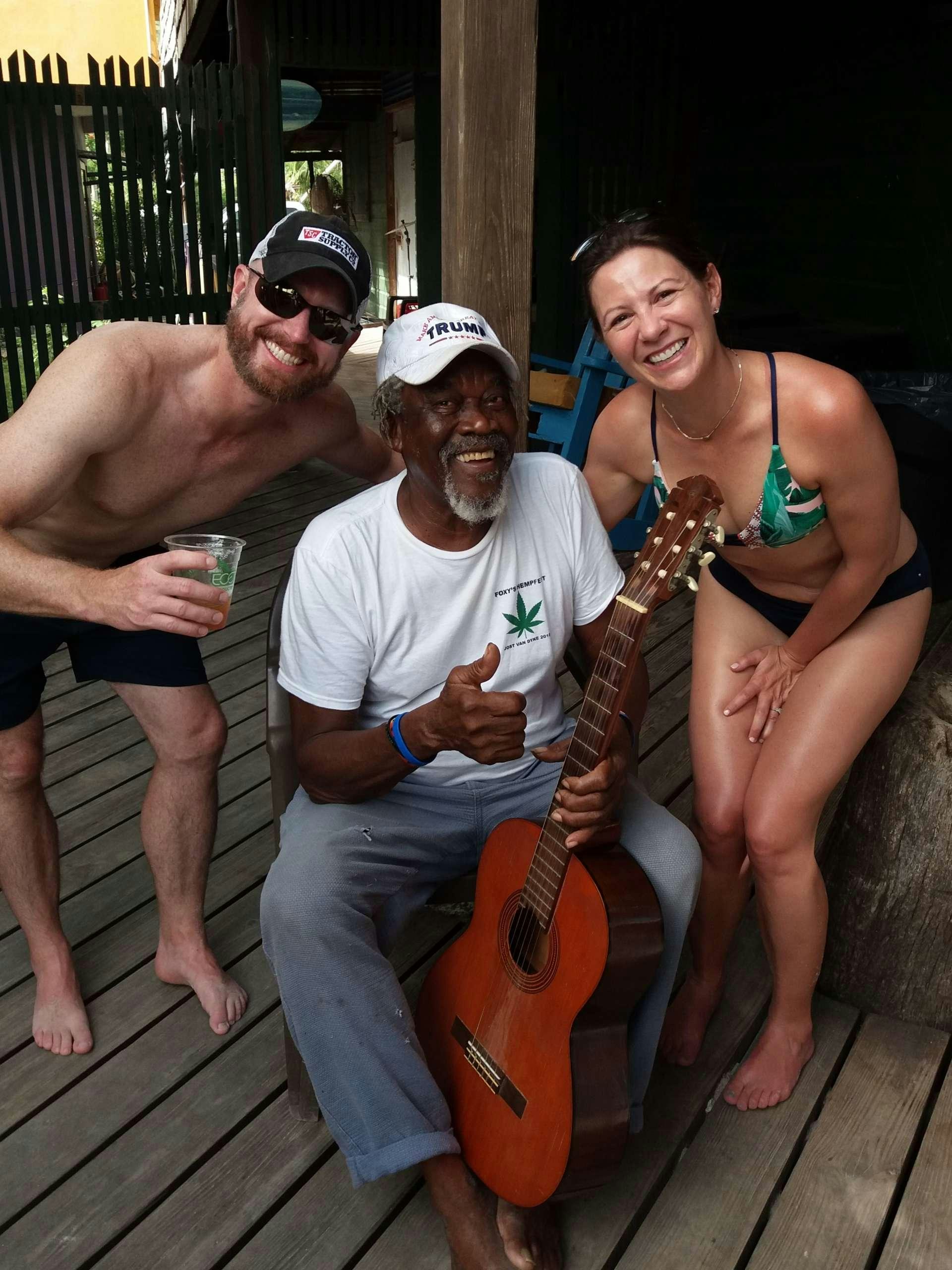 a group of people posing for a photo with a guitar aboard FRENK Yacht for Charter