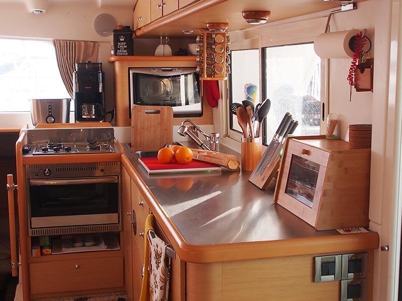 a kitchen with a stove and microwave aboard FRENK Yacht for Charter