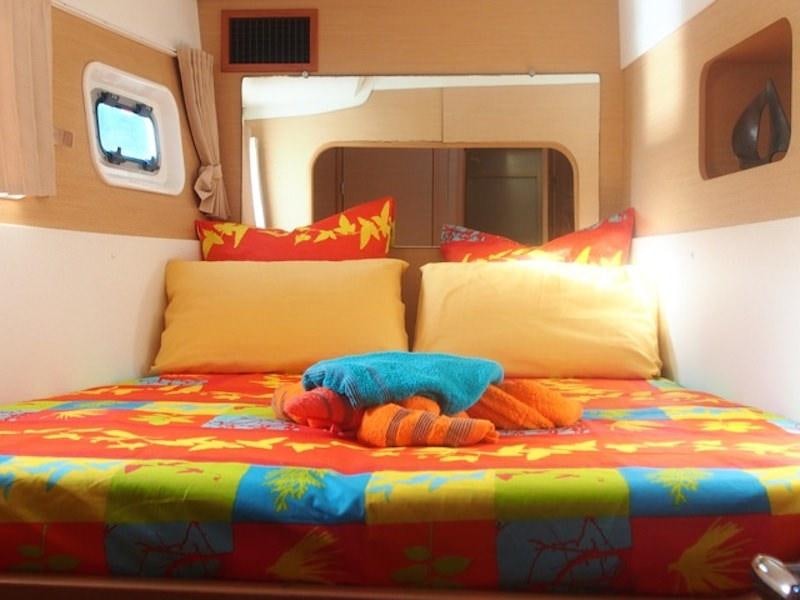 a bed with colorful pillows aboard FRENK Yacht for Charter