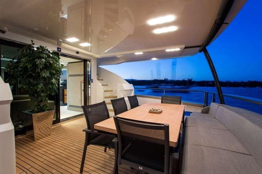 a deck with a table and chairs aboard KEROS ISLAND Yacht for Charter