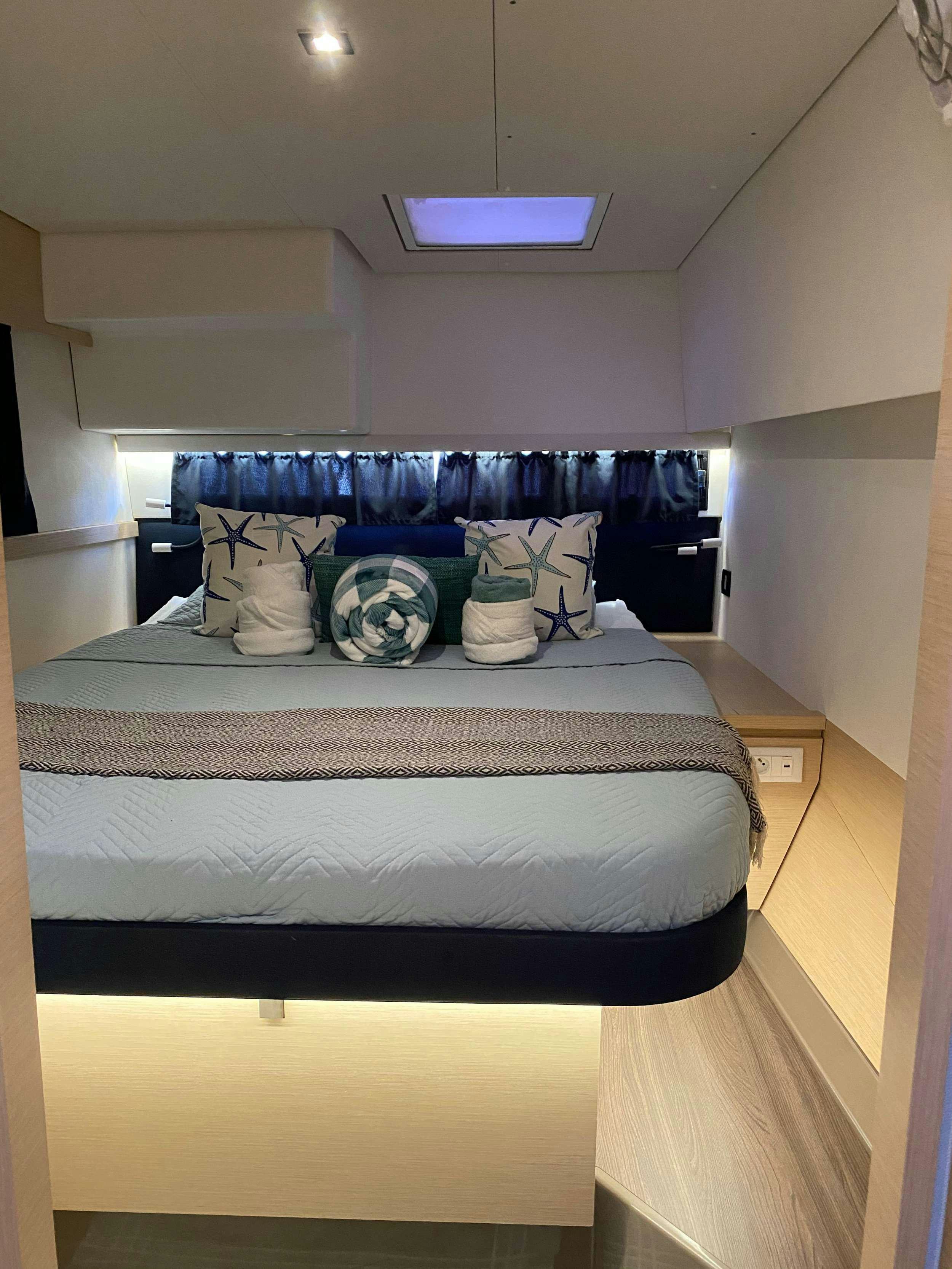 a bed with blue sheets aboard MARIANN Yacht for Charter