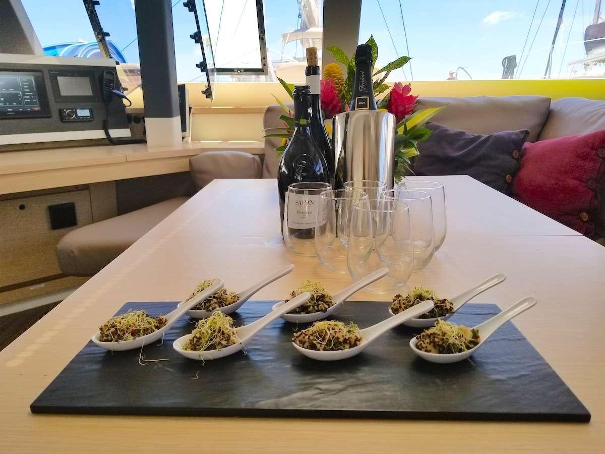 a table with food and wine bottles aboard MARIANN Yacht for Charter