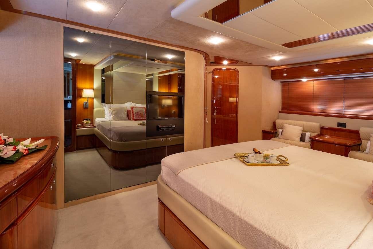 a hotel room with a bed and a television aboard AMOR Yacht for Charter