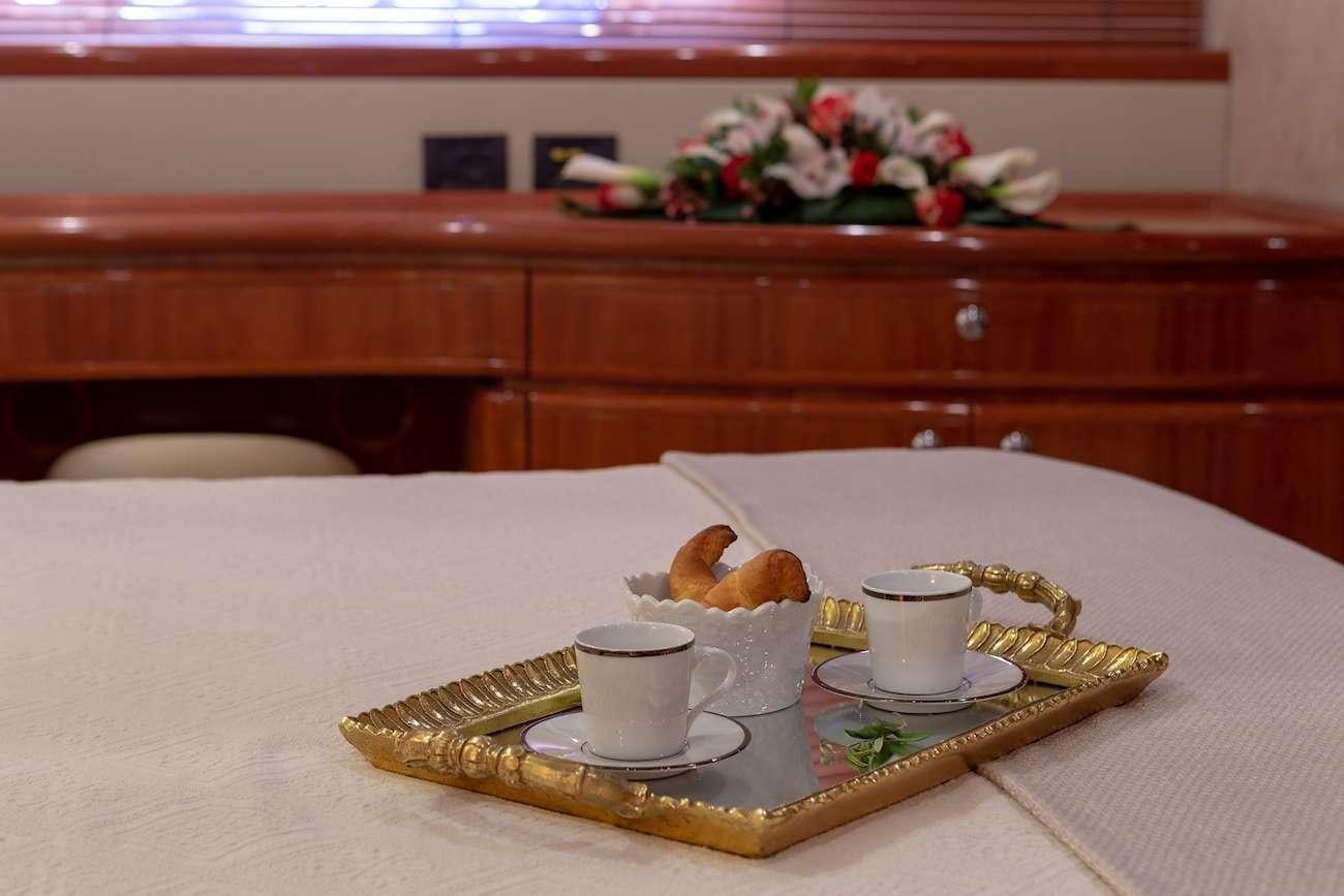 a tray of food and a cup of coffee on a table aboard AMOR Yacht for Charter