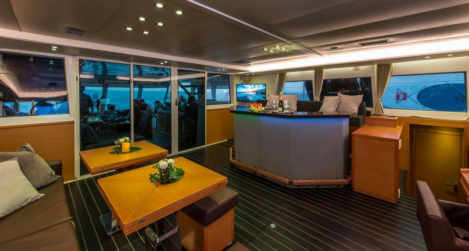 inside of a room with a table and chairs and a tv aboard PRIMETIME Yacht for Charter