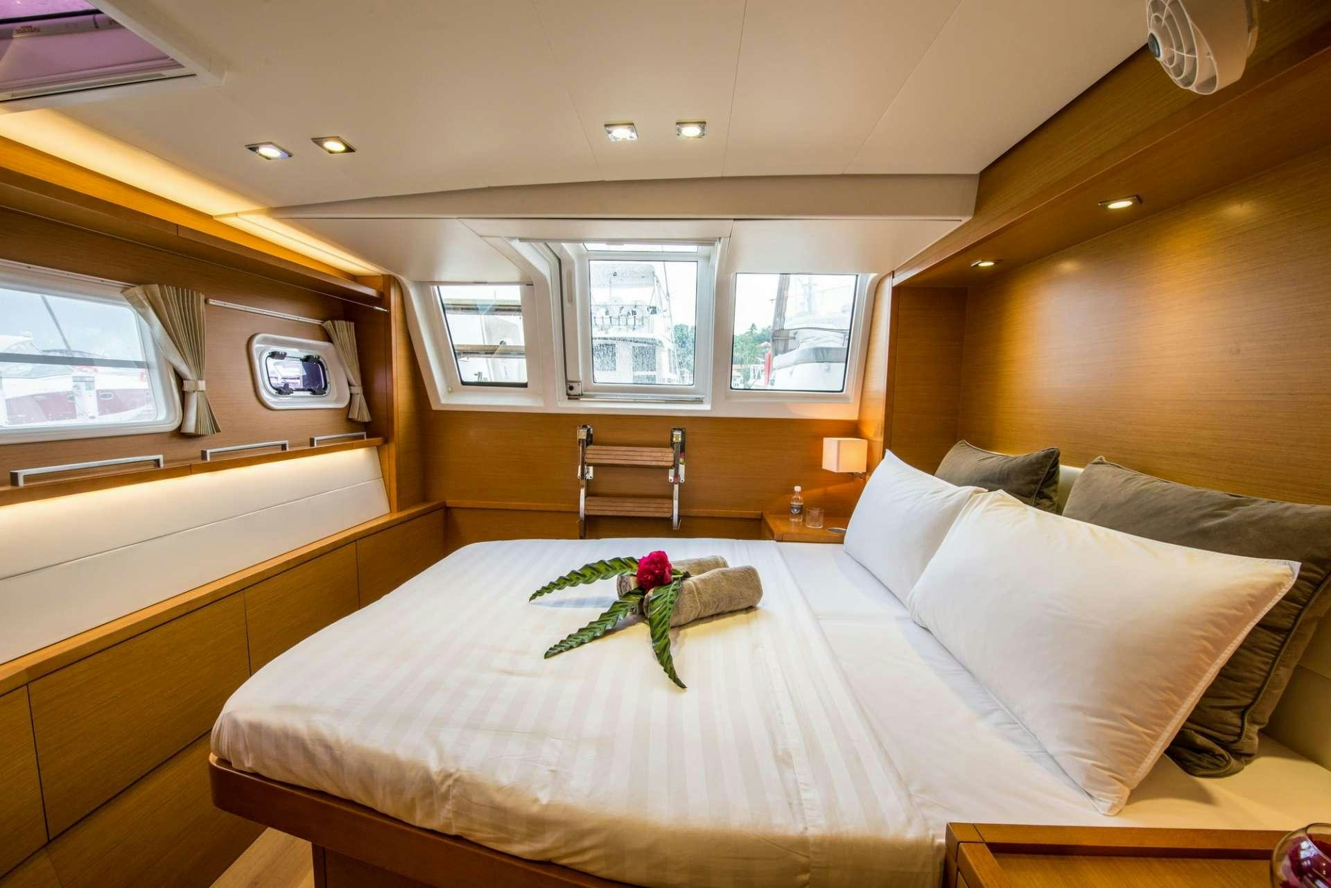 a bed with white sheets and pillows aboard PRIMETIME Yacht for Charter