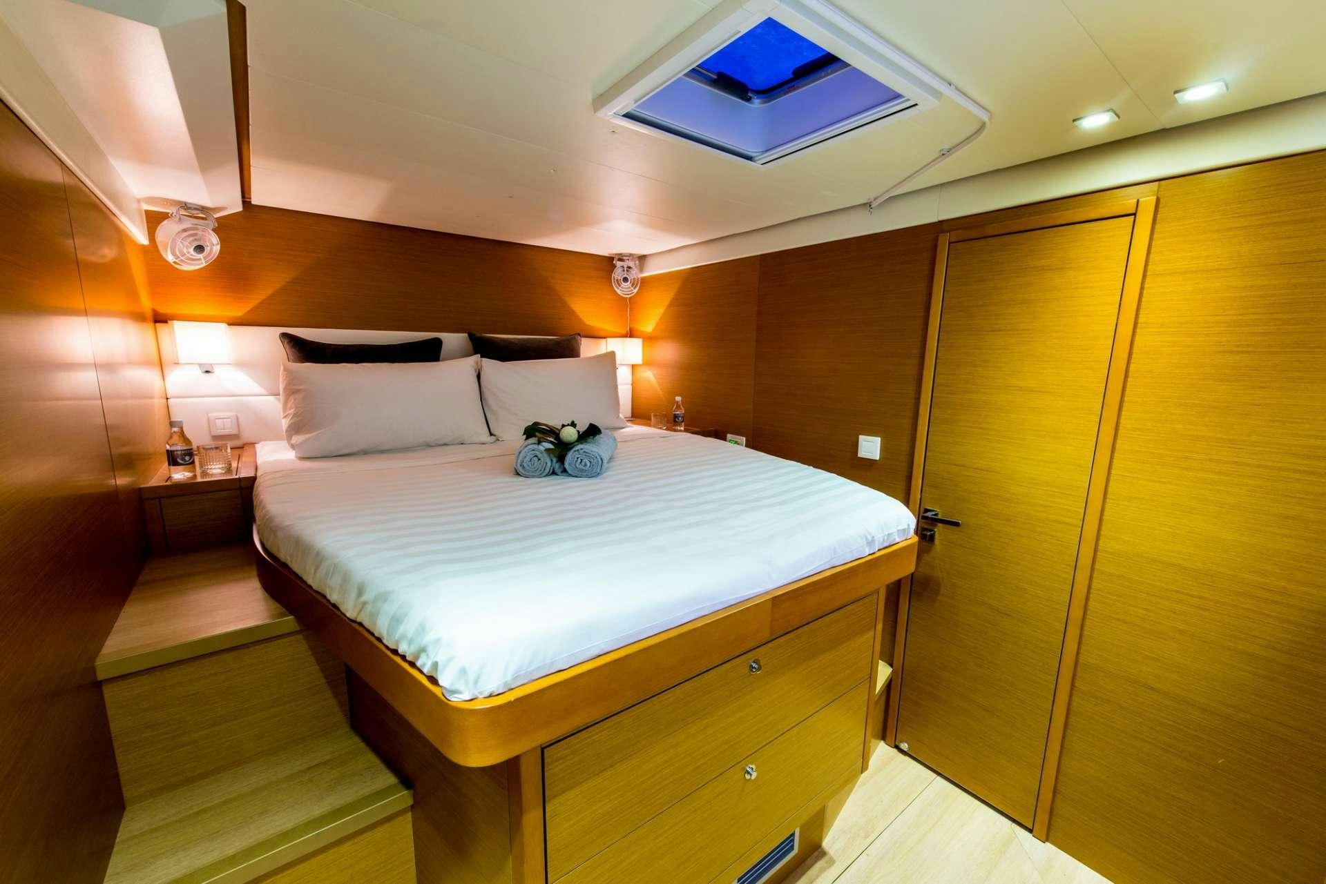 a bed with a white sheet and pillows on it aboard PRIMETIME Yacht for Charter