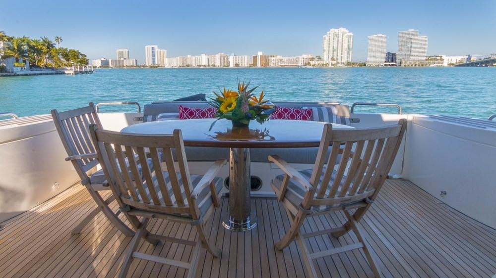 a table and chairs on a deck overlooking a body of water aboard ALL GOOD Yacht for Charter