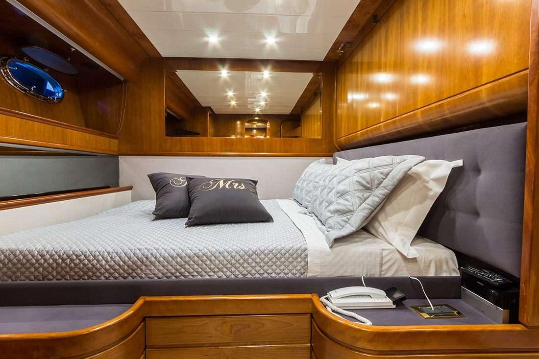 a bed with a white comforter aboard ROCK MOON Yacht for Charter