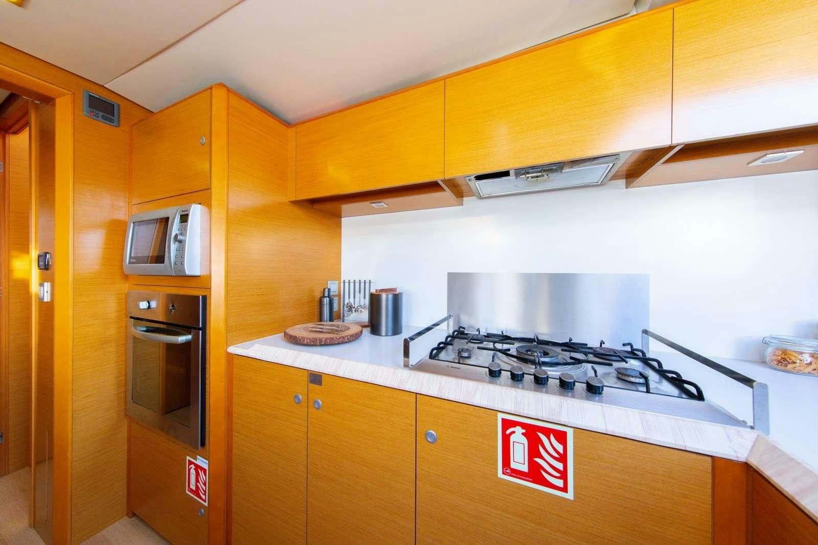 a kitchen with a stove and microwave aboard JYOHANA Yacht for Charter