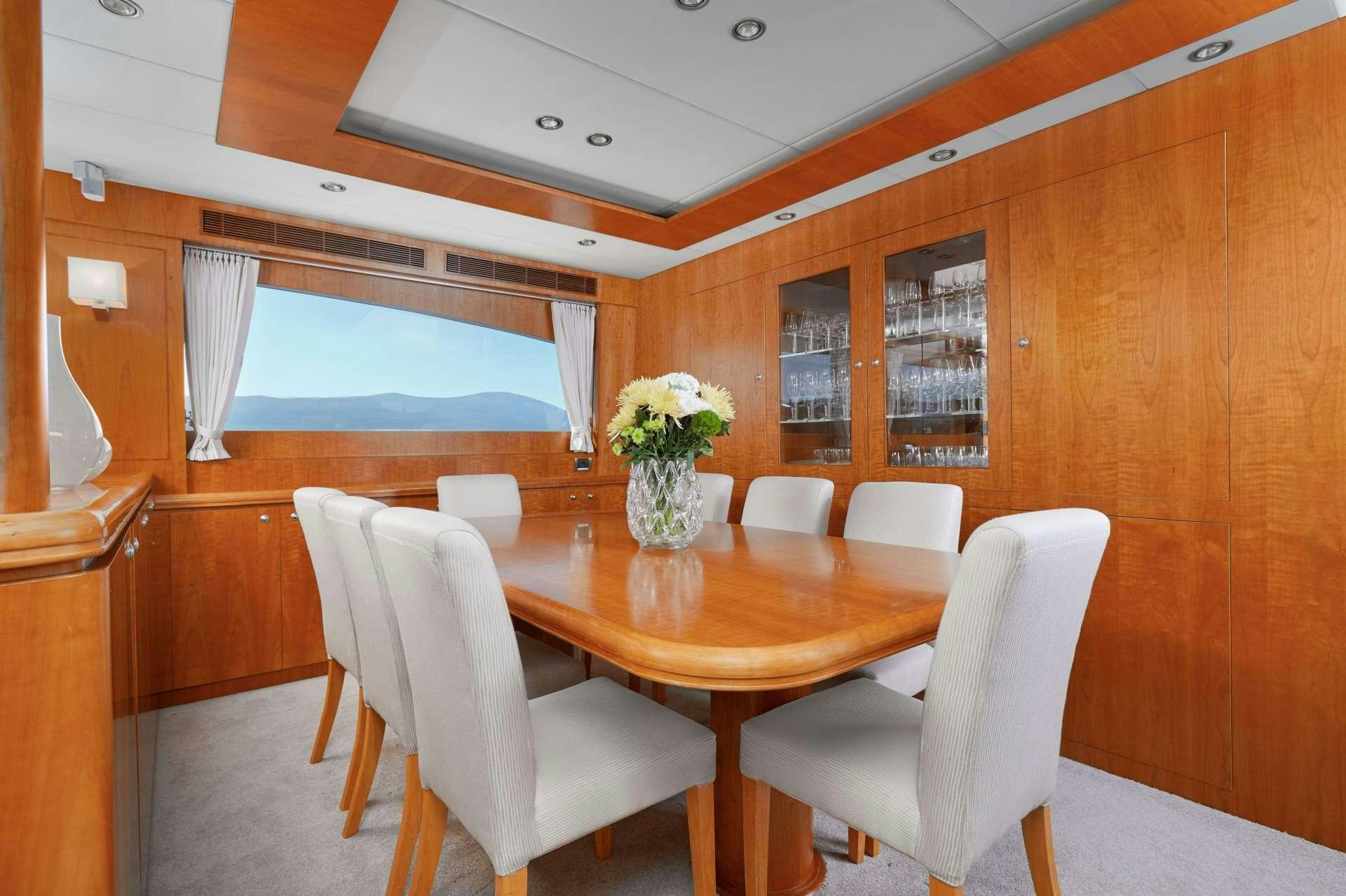 a dining table and chairs in a room with wood walls aboard ANNABEL II Yacht for Charter