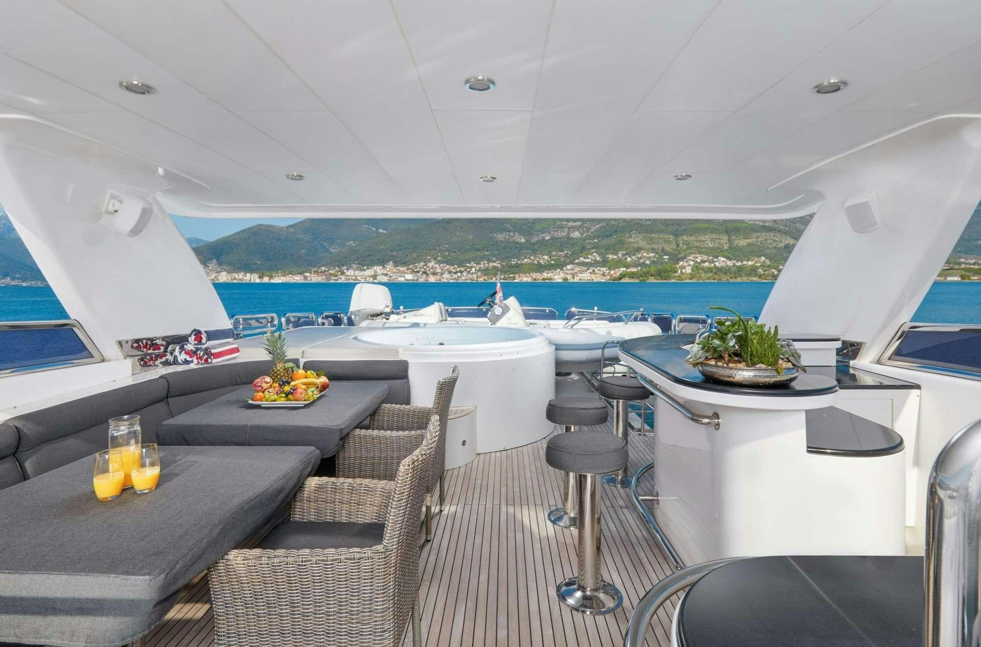 a room with a table chairs and a view of the ocean aboard ANNABEL II Yacht for Charter