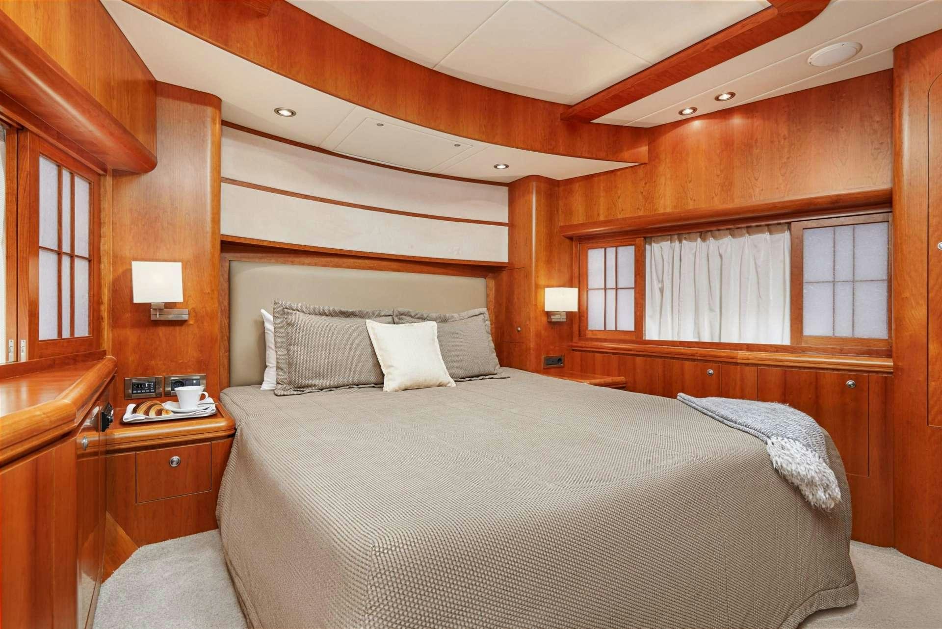 a bed with a white pillow and a wooden headboard aboard ANNABEL II Yacht for Charter