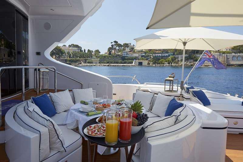 a table with drinks on it next to a boat on a body of water aboard 7 KNOTS Yacht for Charter