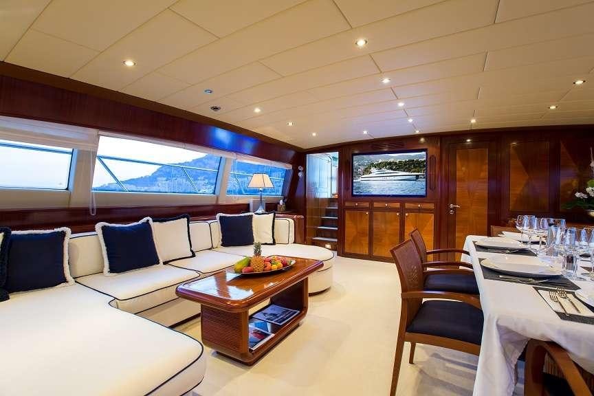 a room with a table chairs and a television aboard 7 KNOTS Yacht for Charter