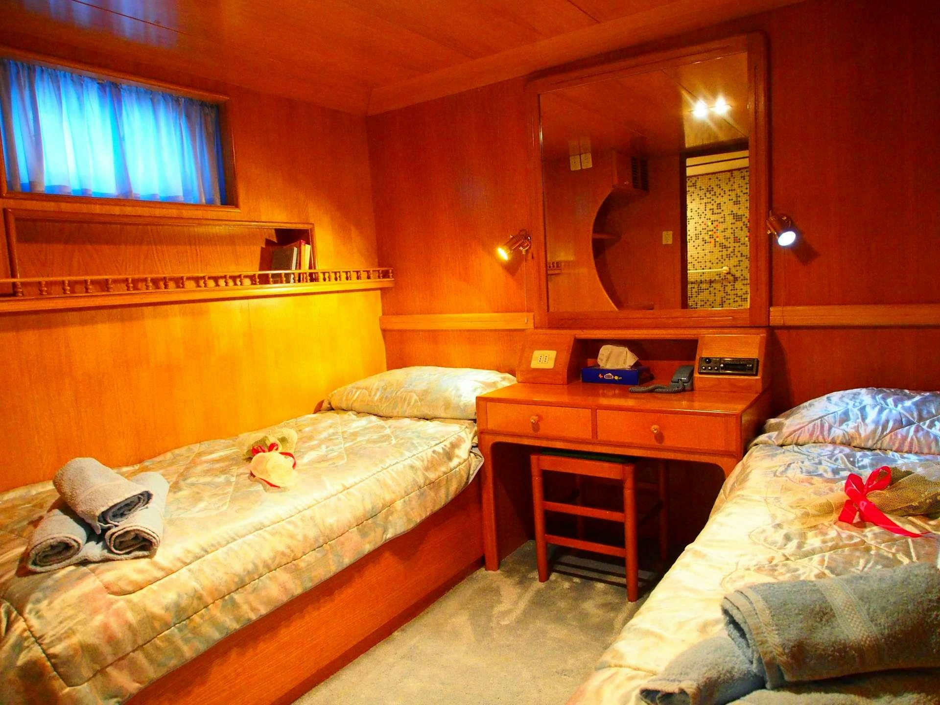 a bedroom with two beds aboard K Yacht for Charter