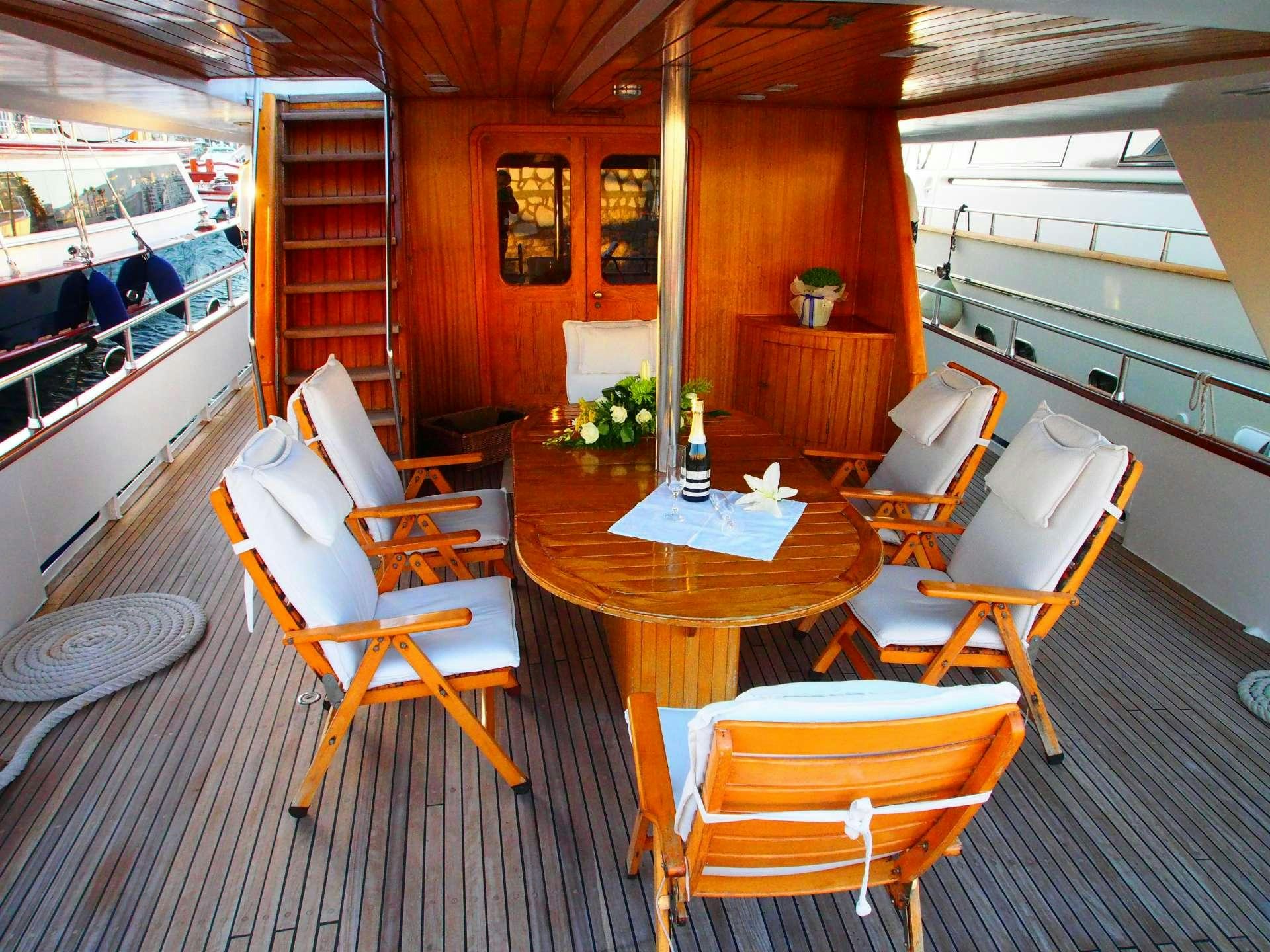 a room with a table chairs and a window aboard K Yacht for Charter