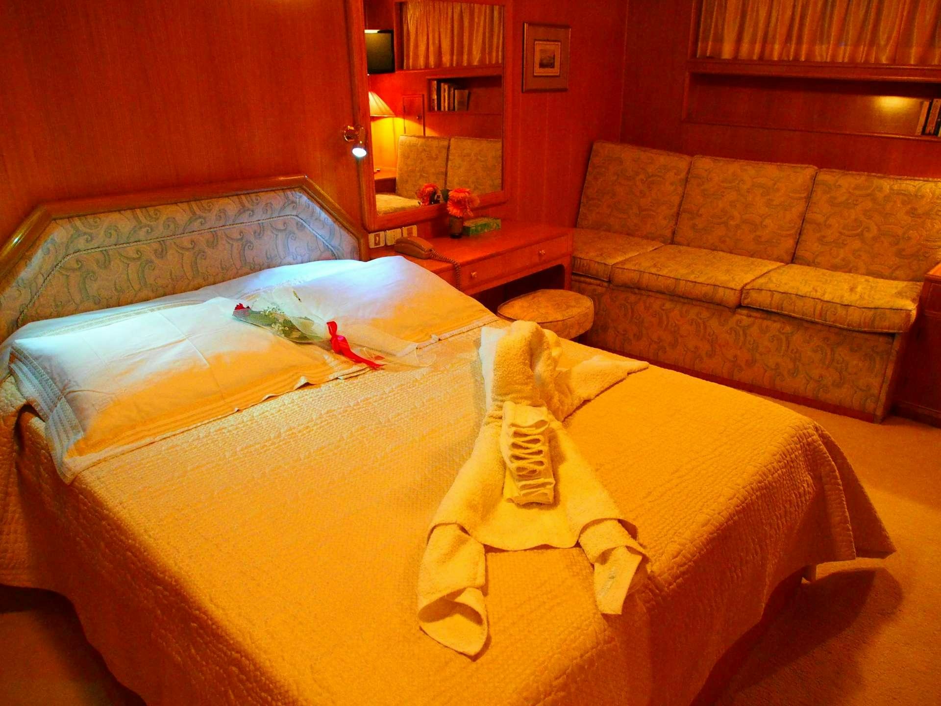 a bed with a stuffed animal aboard K Yacht for Charter