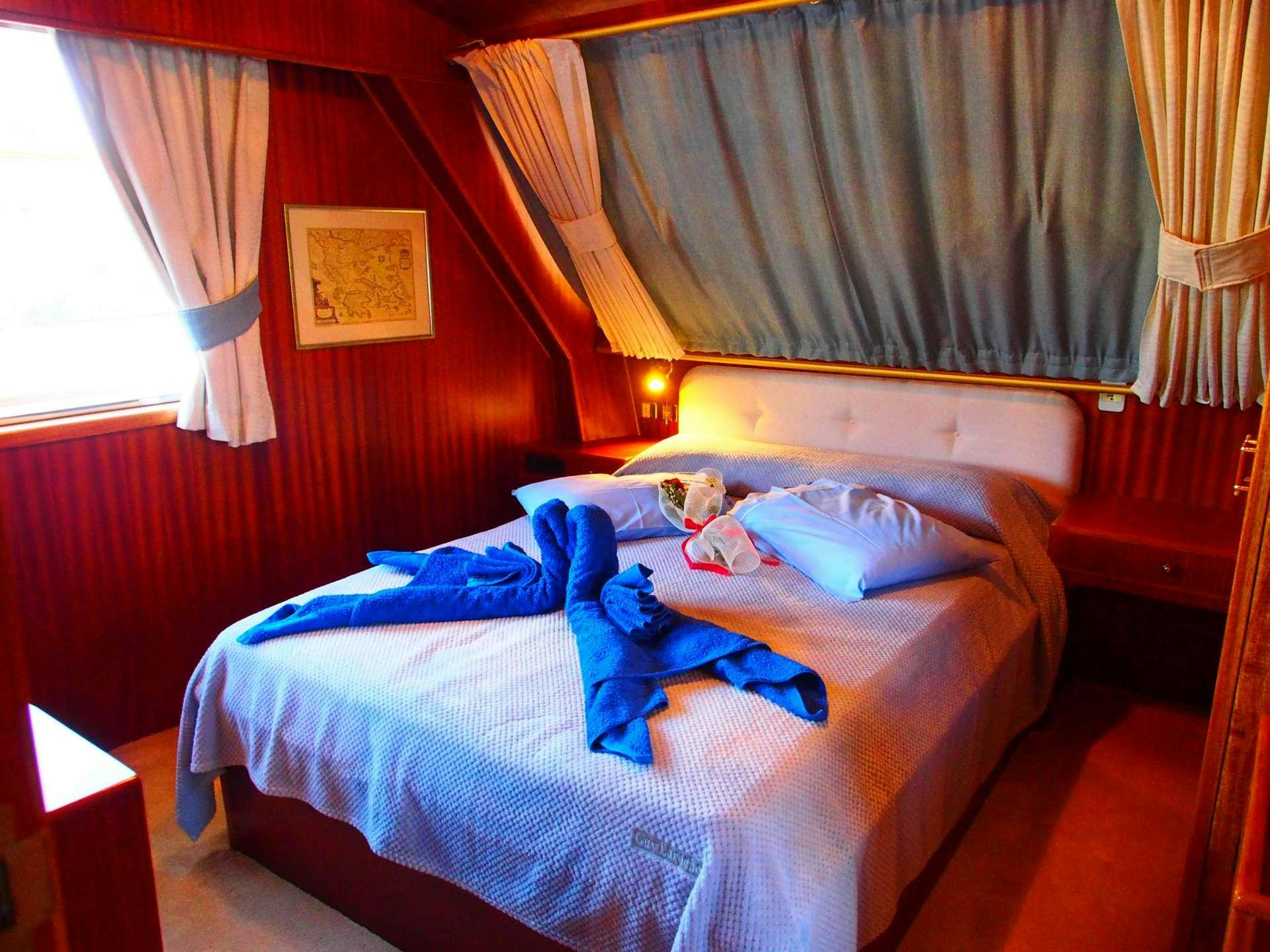 a bed with a blue blanket aboard K Yacht for Charter
