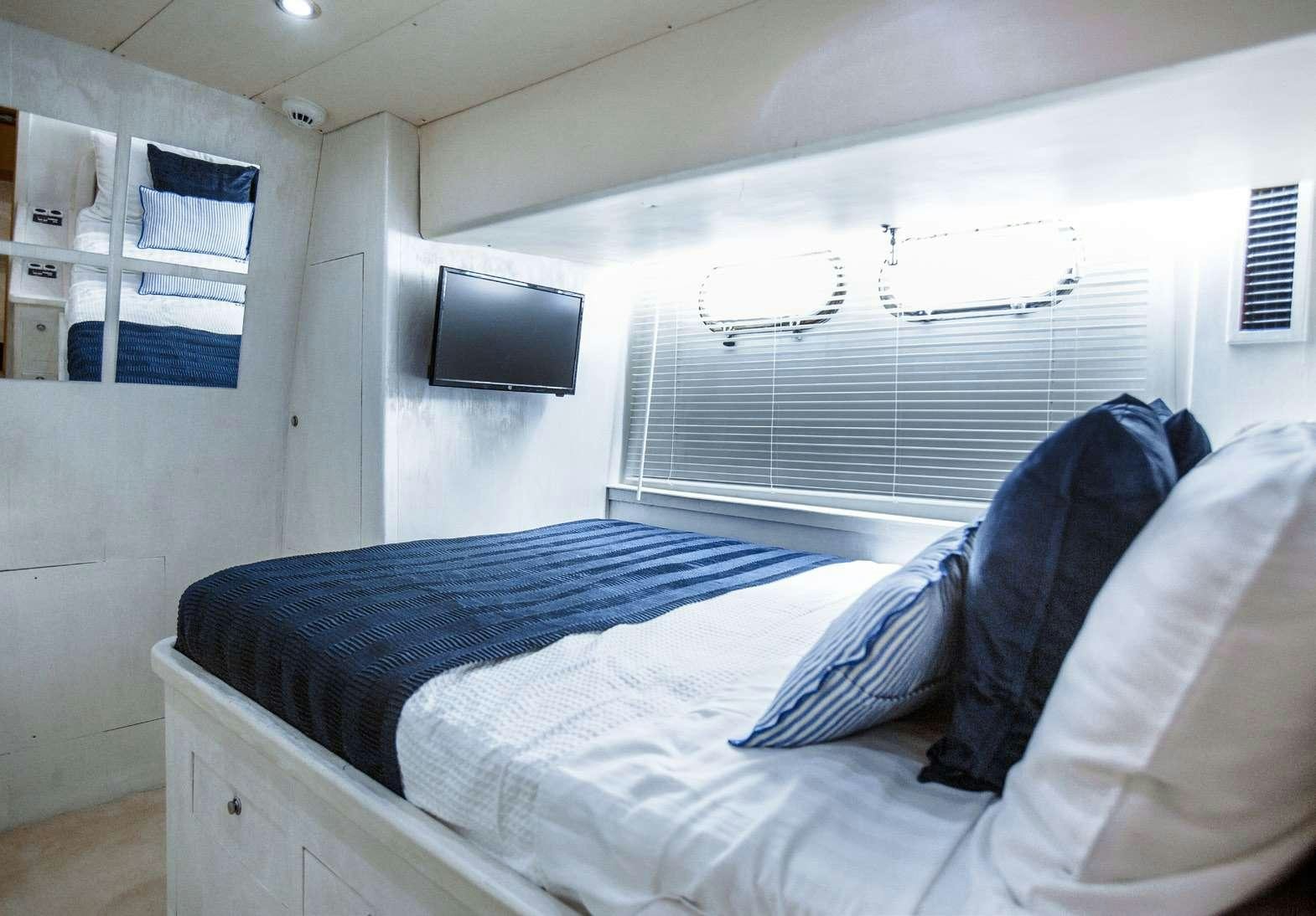 a bed with blue sheets aboard DREAM Yacht for Charter