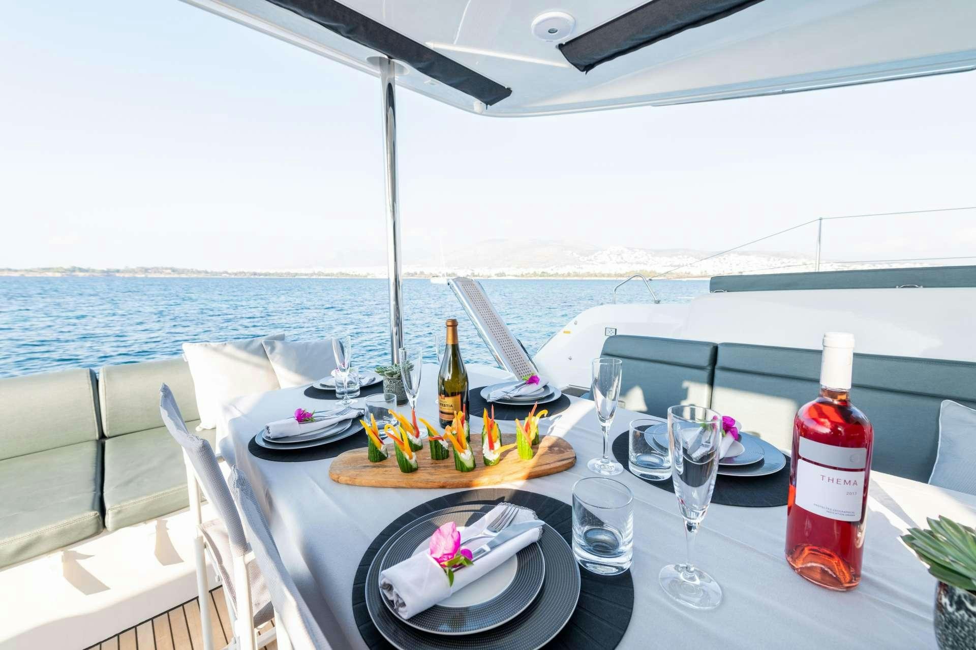 a table with plates and wine bottles on it aboard KaLiMar Yacht for Charter