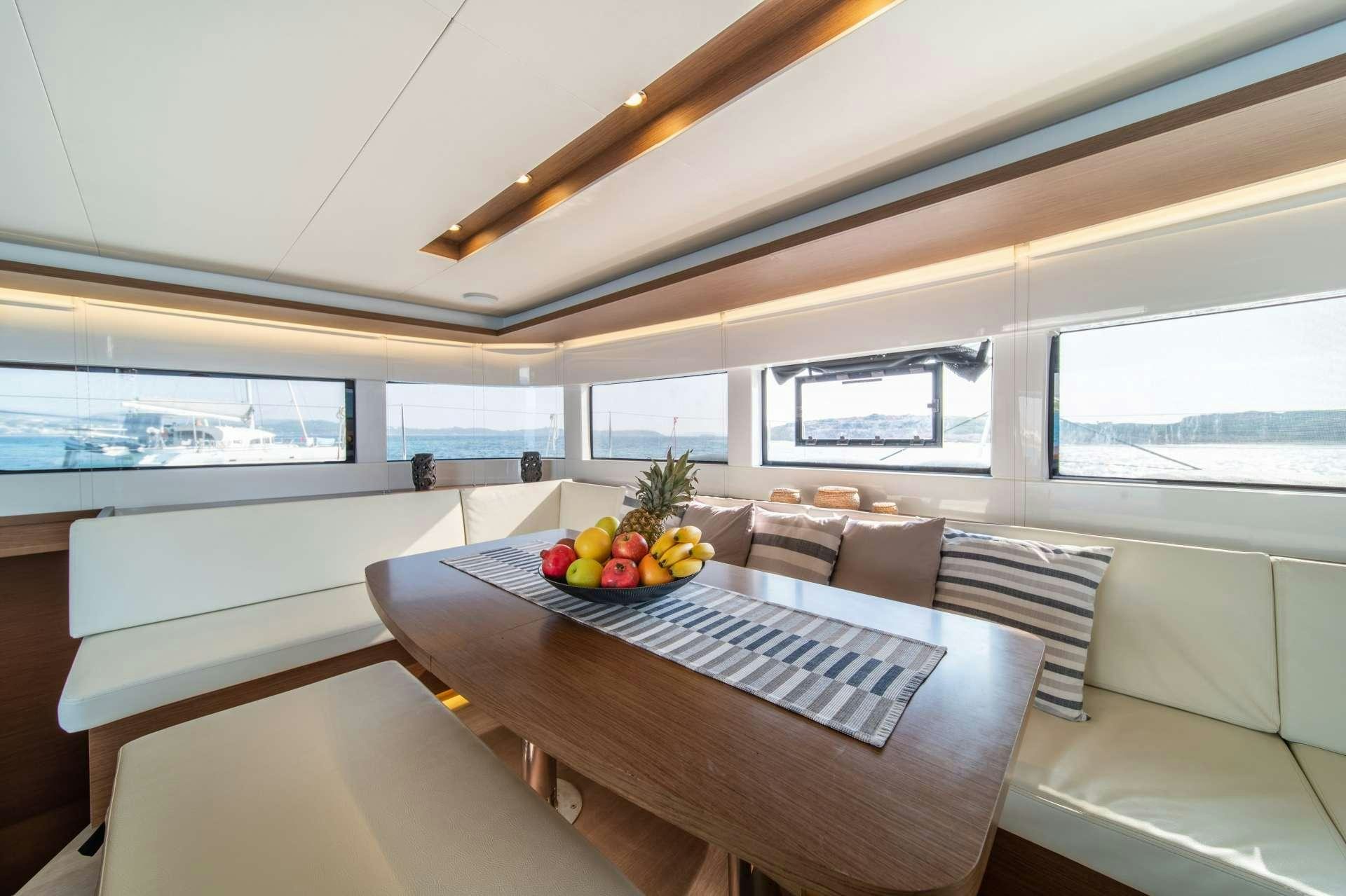 a room with a table and a couch aboard KaLiMar Yacht for Charter