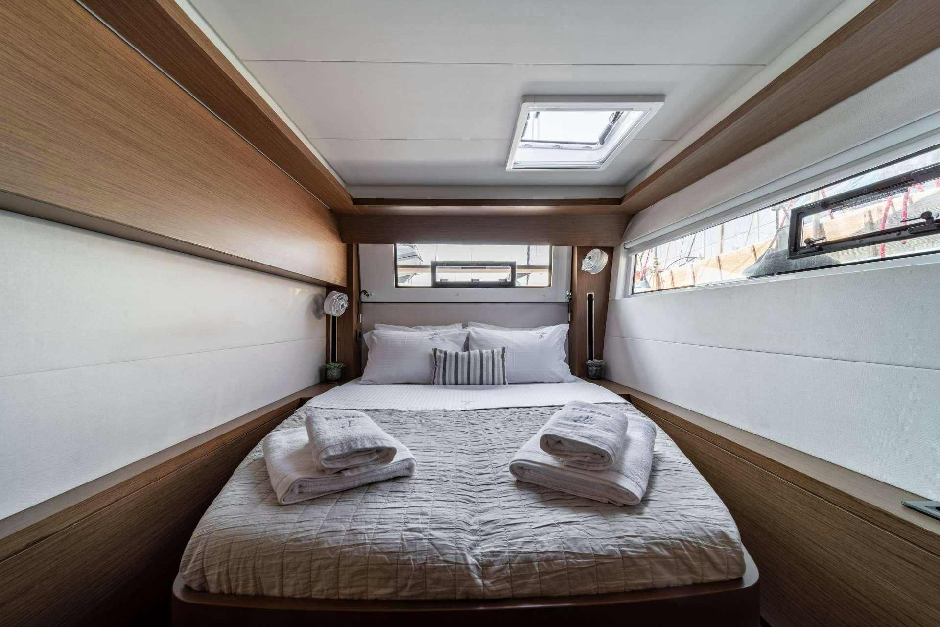 a room with a bed and a window aboard KaLiMar Yacht for Charter