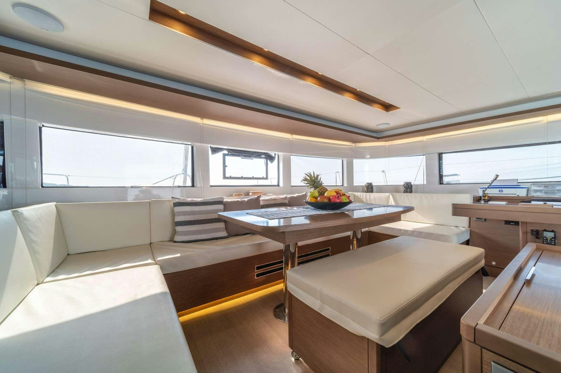 a room with a table and couch aboard KaLiMar Yacht for Charter