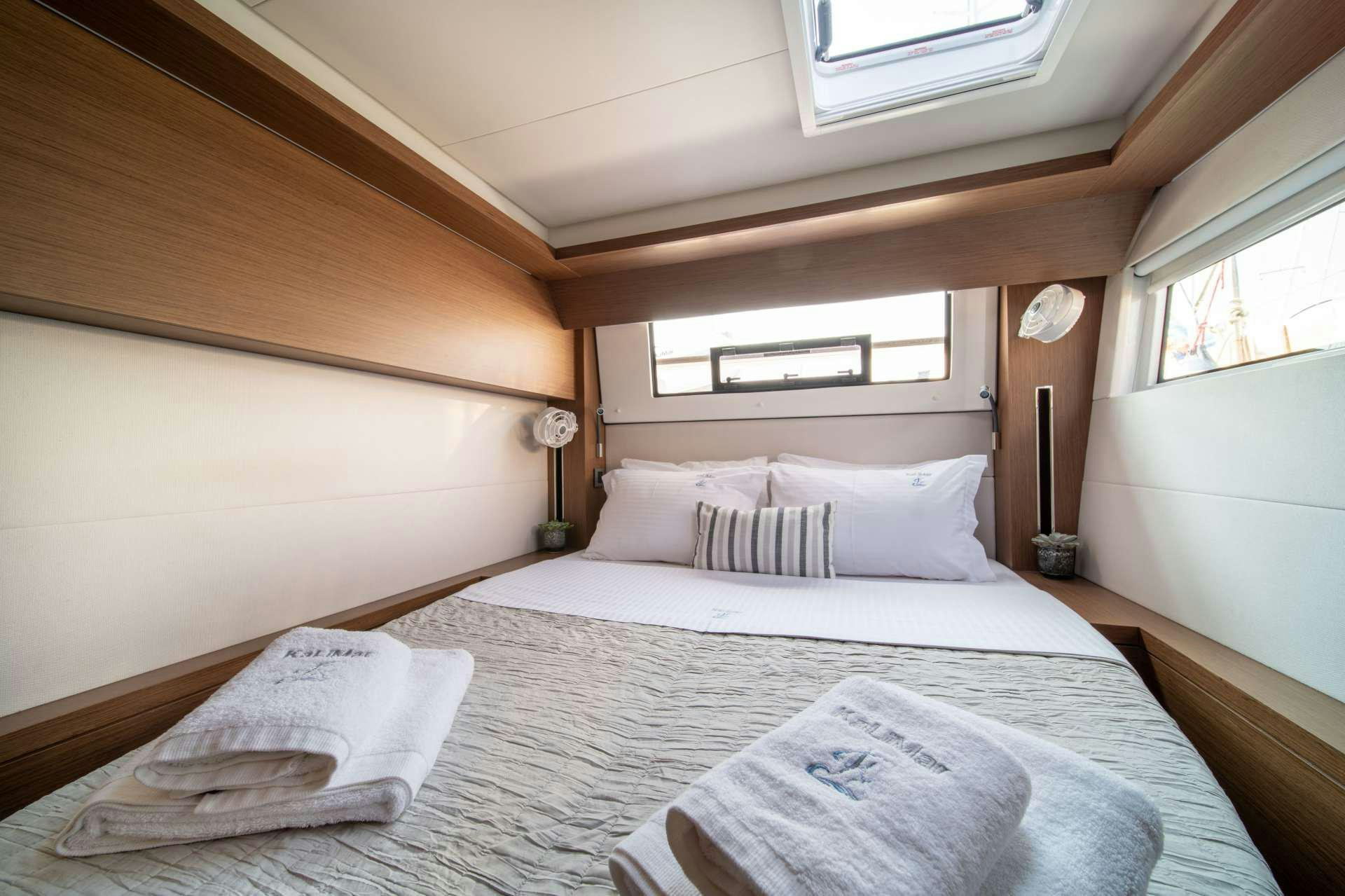 a bed with white sheets aboard KaLiMar Yacht for Charter