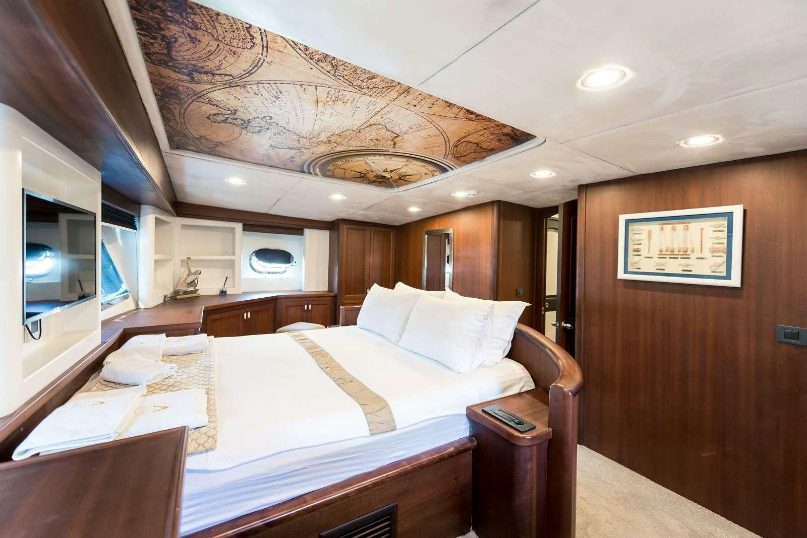 a bedroom with a bed and a television aboard VIRTUOSO Yacht for Charter