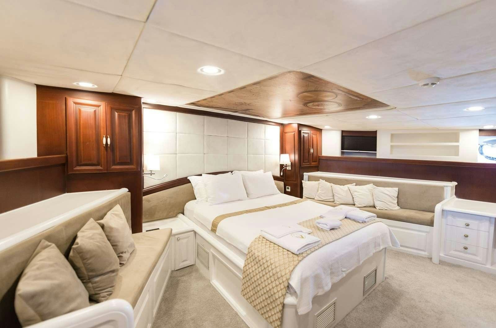 a room with a bed and a couch aboard VIRTUOSO Yacht for Charter