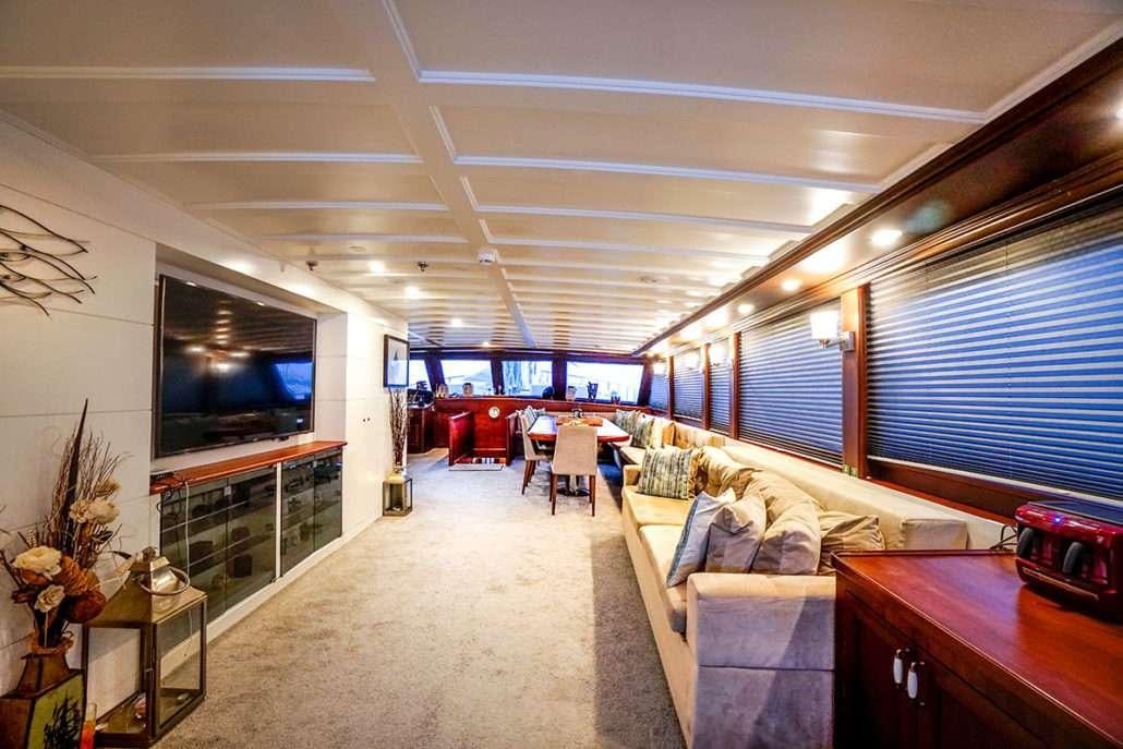 a living room with a couch and a tv aboard VIRTUOSO Yacht for Charter