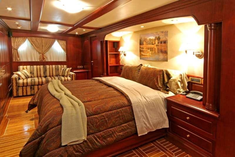 a bedroom with a bed and a desk aboard BLUE DREAM Yacht for Charter