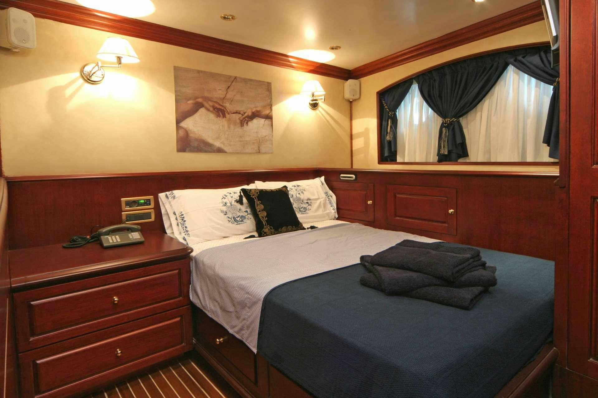 a room with a bed and a desk aboard BLUE DREAM Yacht for Charter