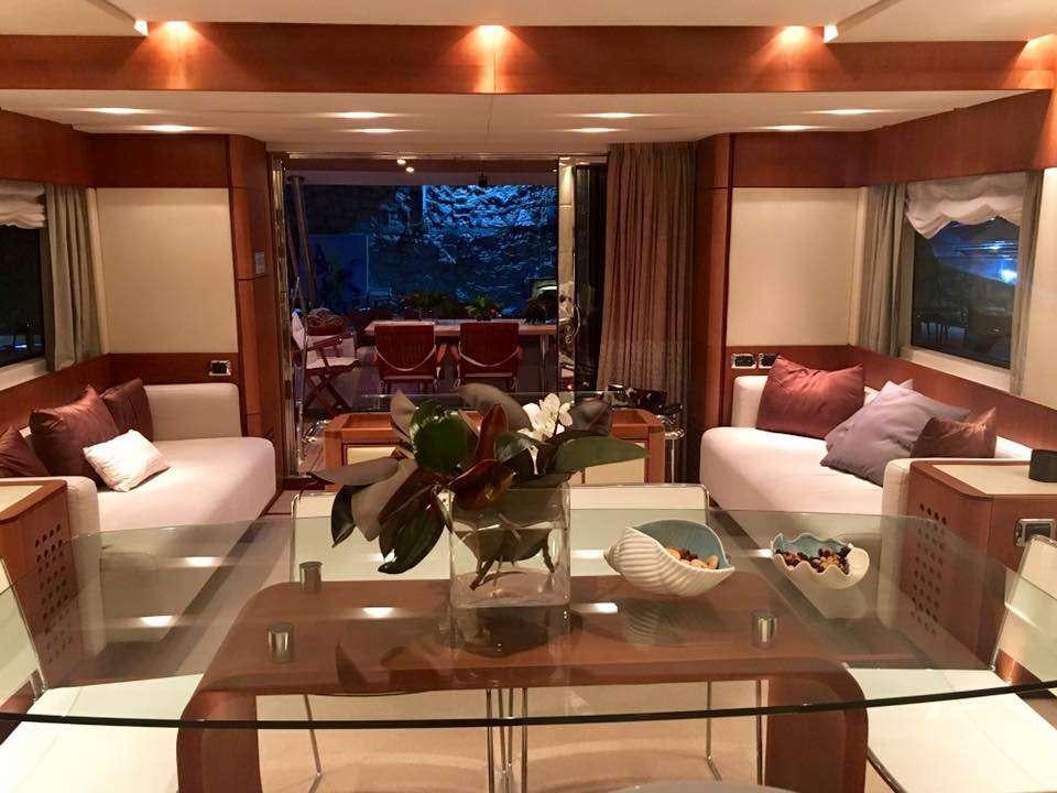 a living room with a table and couches aboard QUESTA E VITA Yacht for Charter