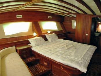 a bed with a white sheet aboard KAPTAN YILMAZ Yacht for Charter