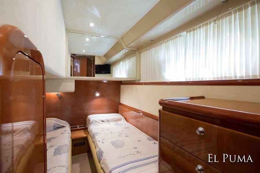 a room with a bed and a chair aboard EL PUMA Yacht for Charter