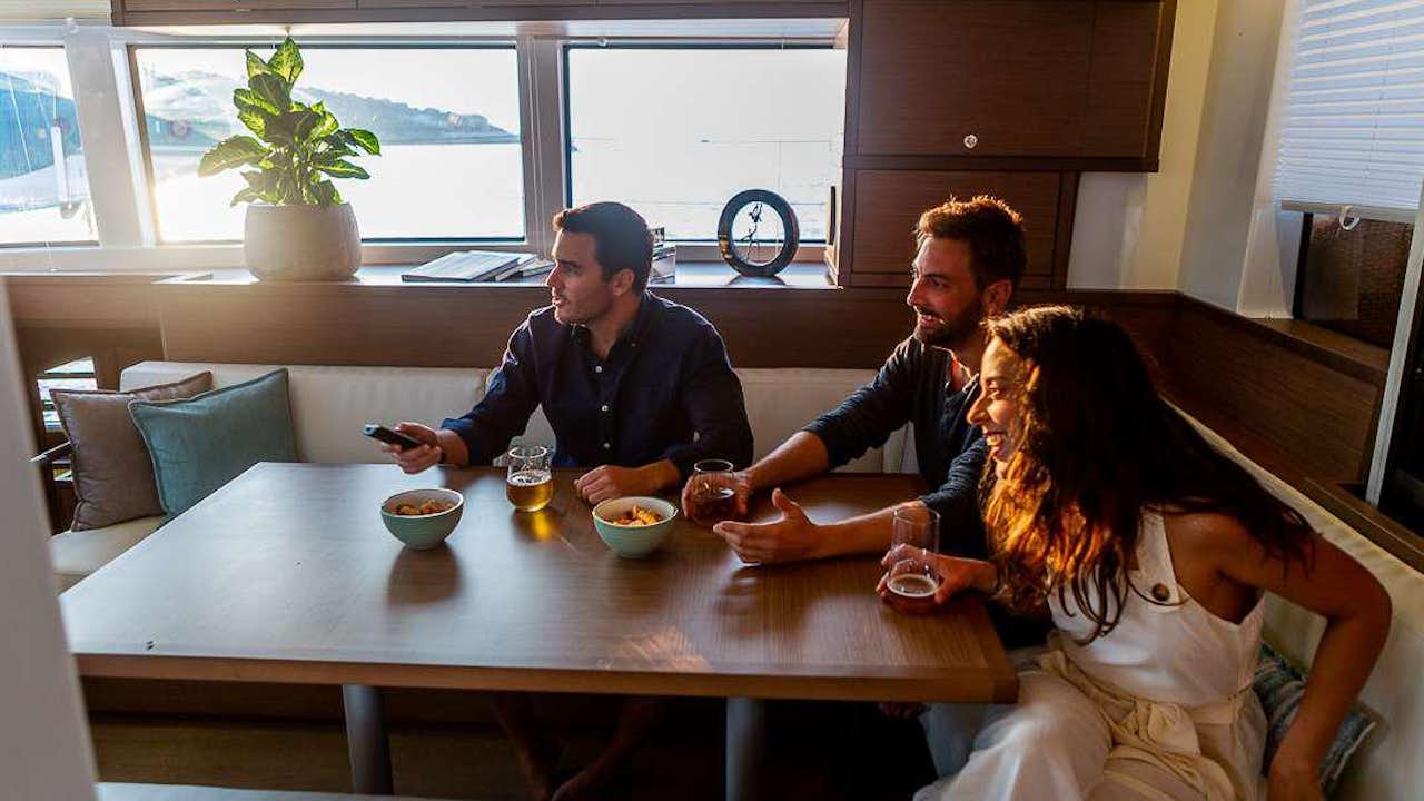 a group of people sitting around a table with food and drinks aboard VALIUM 52 Yacht for Charter