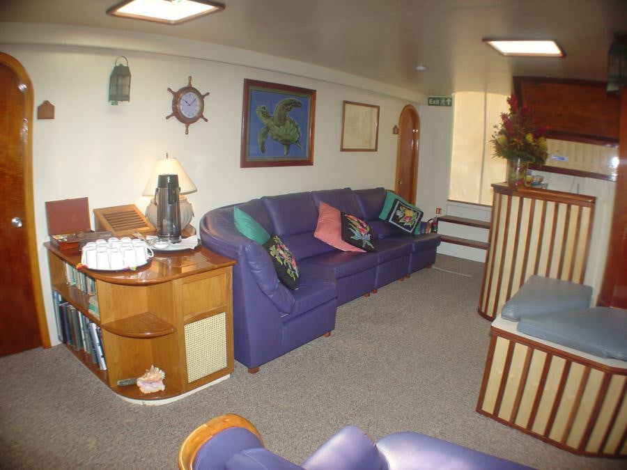 a living room with a blue couch aboard CUAN LAW Yacht for Charter